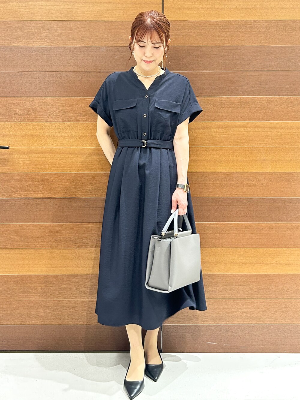 ブルー系のワンピース、グレー系のトートバッグ、ブラック系のパンプスを着用したレディースの夏コーディネートの2枚目の写真