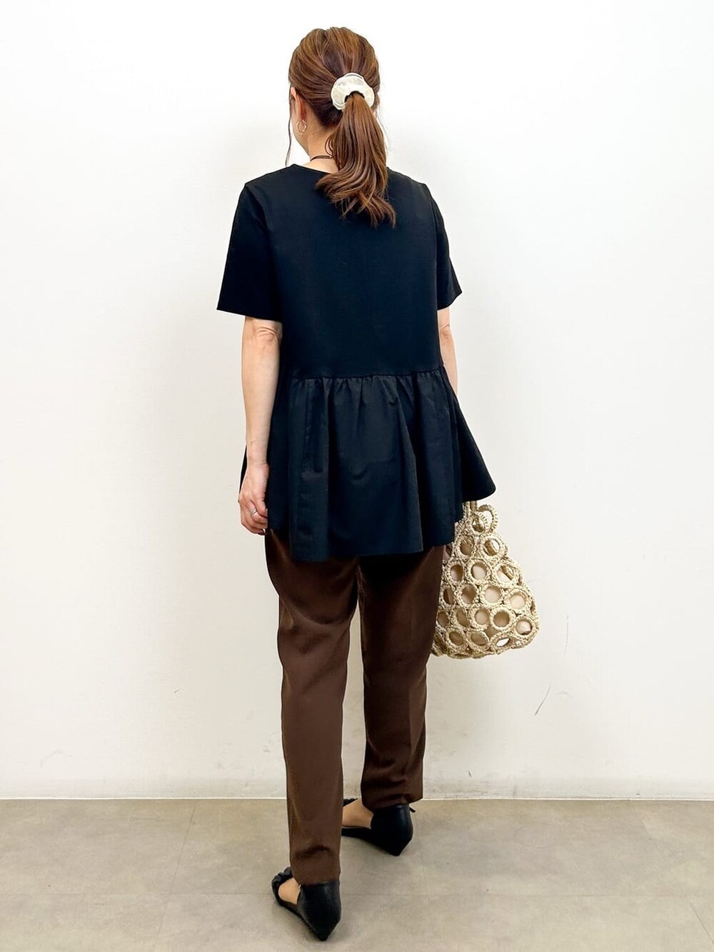 ブラック系のTシャツ/カットソー、ブラウン系のその他パンツ、ホワイト系のハンドバッグを着用したレディースの夏コーディネートの6枚目の写真