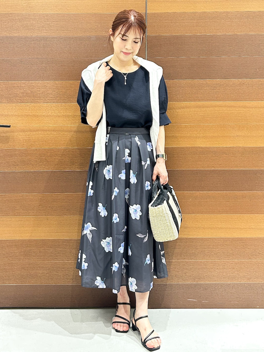 ホワイト系のカーディガン/ボレロ、ブルー系のシャツ/ブラウス、グレー系のスカートを着用したレディースの夏コーディネートの3枚目の写真