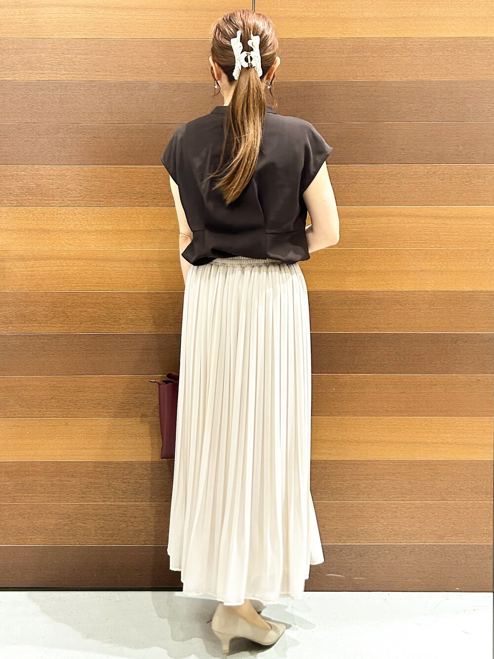 ブラウン系のシャツ/ブラウス、ベージュ系のスカート、レッド系のトートバッグを着用したレディースの夏コーディネートの6枚目の写真
