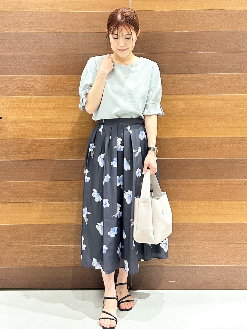 グリーン系のシャツ/ブラウス、グレー系のスカート、グレー系のトートバッグを着用したレディースの夏コーディネートの3枚目の写真