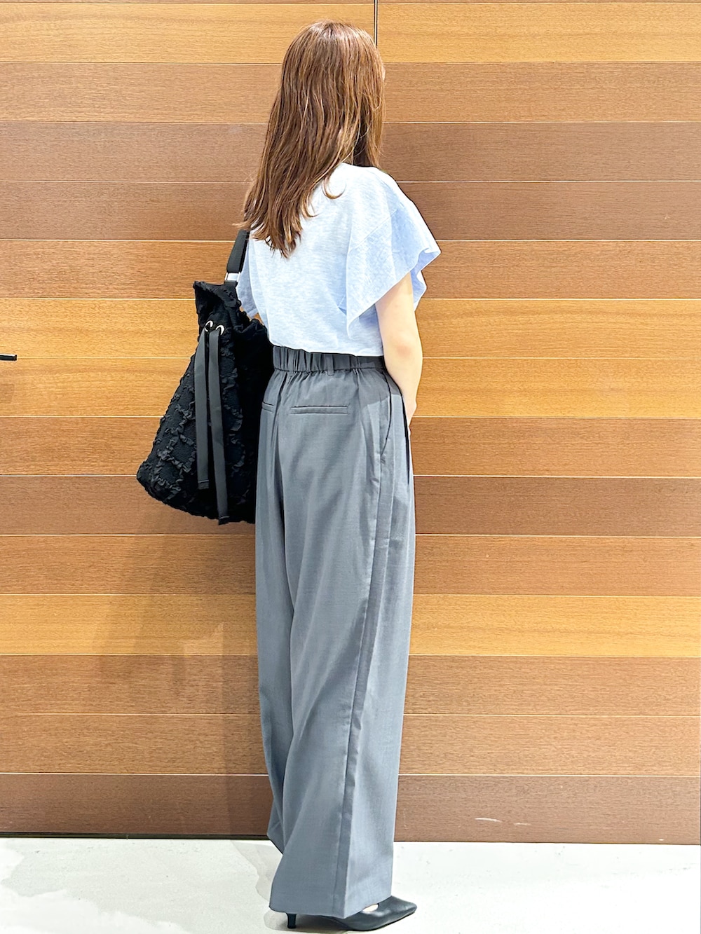 ブルー系のニット/セーター、グレー系のその他パンツ、ブラック系のトートバッグを着用したレディースの夏コーディネートの5枚目の写真