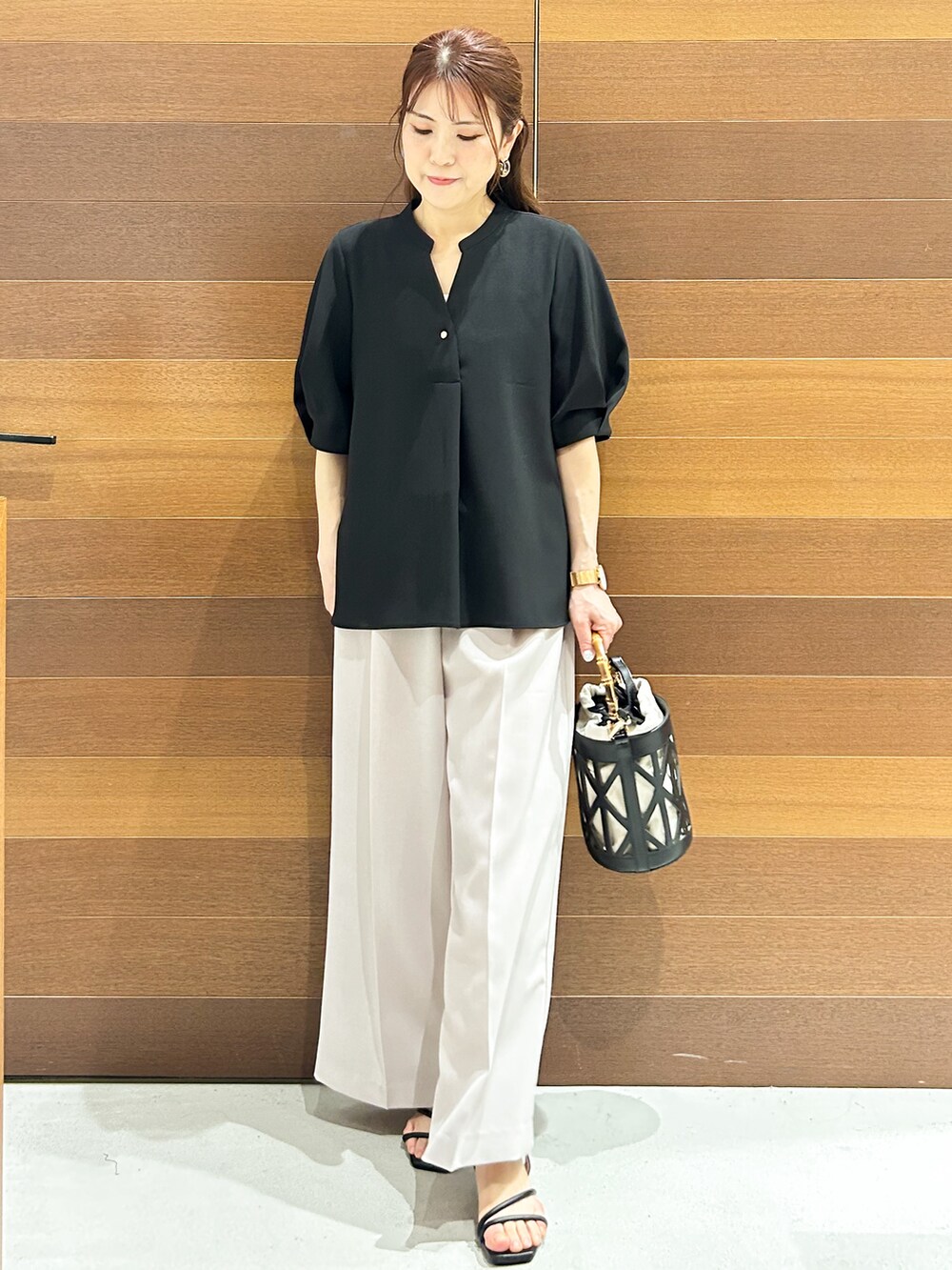ブラック系のシャツ/ブラウス、ベージュ系のその他パンツ、ブラック系のハンドバッグを着用したレディースの春コーディネートの3枚目の写真
