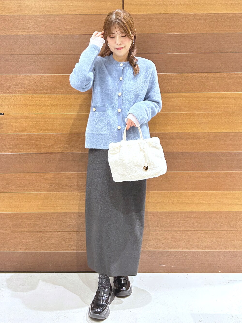 ブルー系のカーディガン/ボレロ、グレー系のTシャツ/カットソー、グレー系のスカートを着用したレディースの秋コーディネートの2枚目の写真
