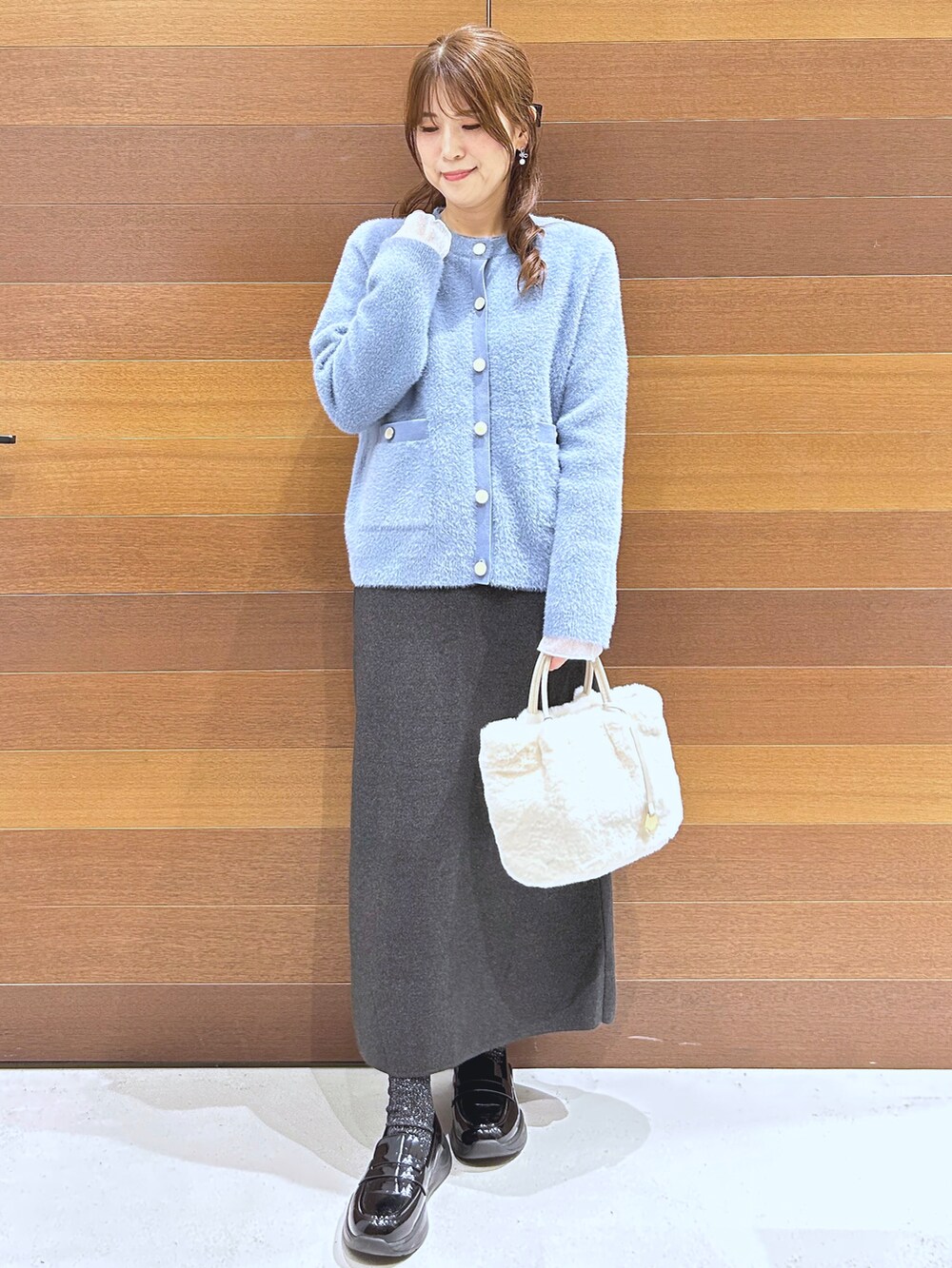 ブルー系のカーディガン/ボレロ、グレー系のTシャツ/カットソー、グレー系のスカートを着用したレディースの秋コーディネートの3枚目の写真