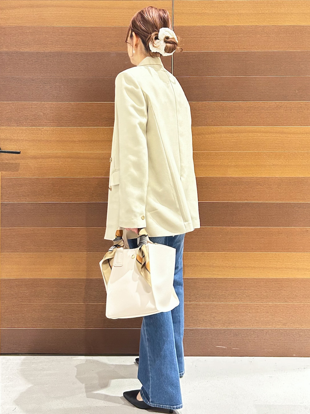 ブルー系のデニムパンツ、ホワイト系のショルダーバッグ、ブラック系のパンプスを着用したレディースの春コーディネートの6枚目の写真