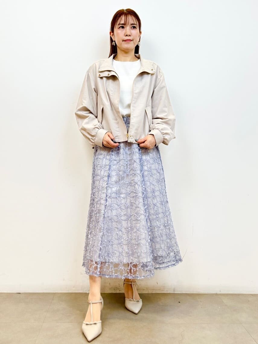 ホワイト系のニット/セーター、ブルー系のスカート、ベージュ系のパンプスを着用したレディースの春コーディネートの4枚目の写真