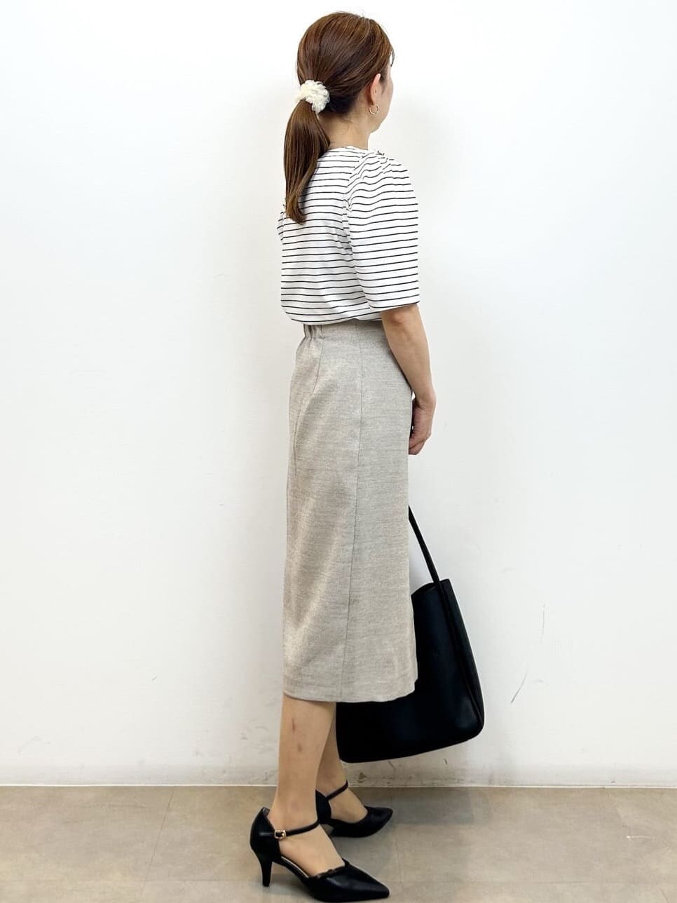 ホワイト系のTシャツ/カットソー、ベージュ系のスカート、ブラック系のトートバッグを着用したレディースの夏コーディネートの6枚目の写真