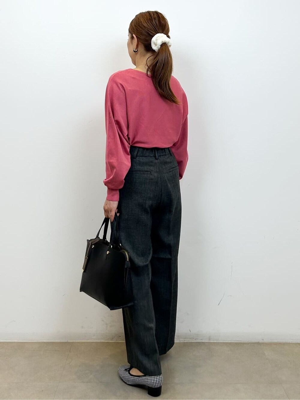 ピンク系のニット/セーター、グレー系のその他パンツ、ブラック系のトートバッグを着用したレディースの秋コーディネートの7枚目の写真