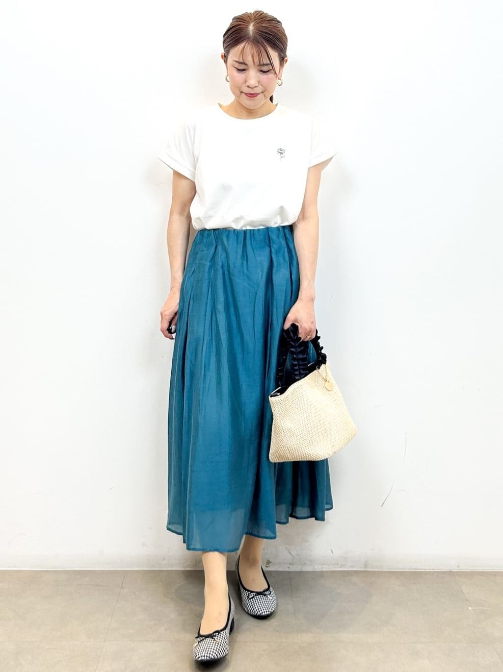 ホワイト系のTシャツ/カットソー、ブルー系のスカート、ブラック系のトートバッグを着用したレディースの夏コーディネートの2枚目の写真