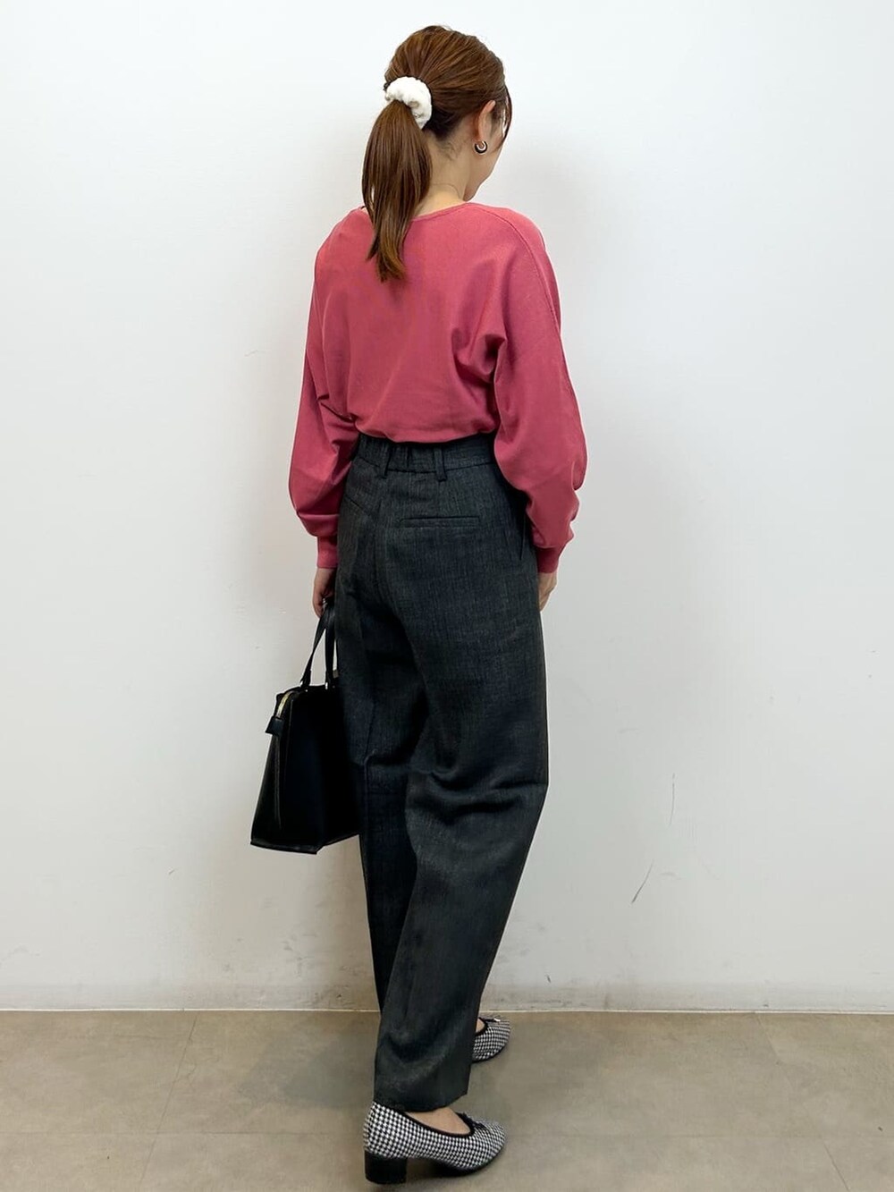 ピンク系のニット/セーター、グレー系のその他パンツ、ブラック系のトートバッグを着用したレディースの秋コーディネートの5枚目の写真