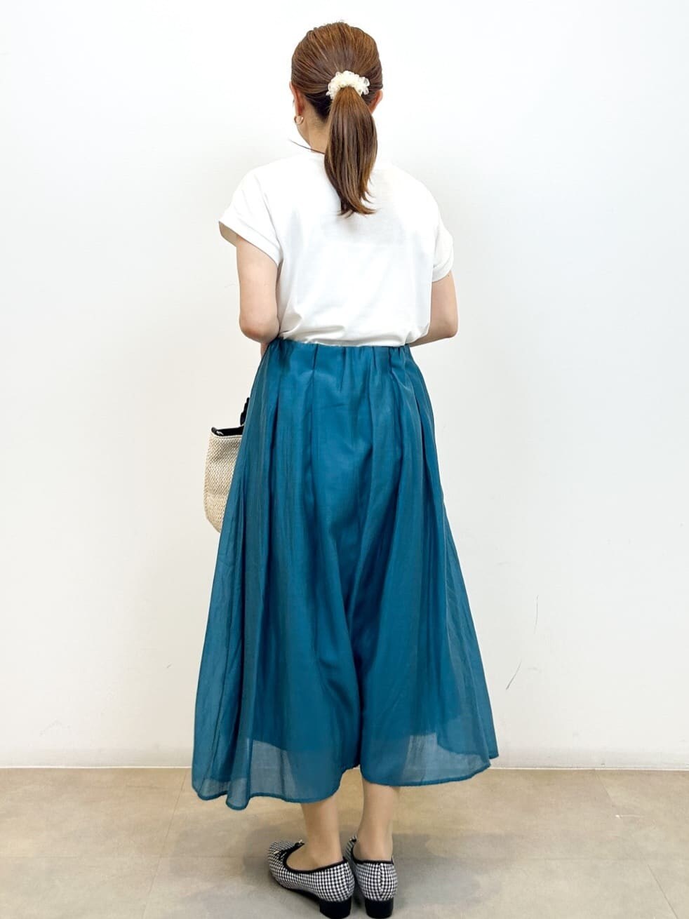ホワイト系のTシャツ/カットソー、ブルー系のスカート、ブラック系のトートバッグを着用したレディースの夏コーディネートの9枚目の写真