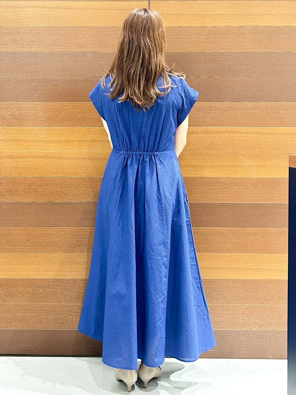 ブルー系のワンピース、グレー系のトートバッグ、ベージュ系のパンプスを着用したレディースの夏コーディネートの5枚目の写真