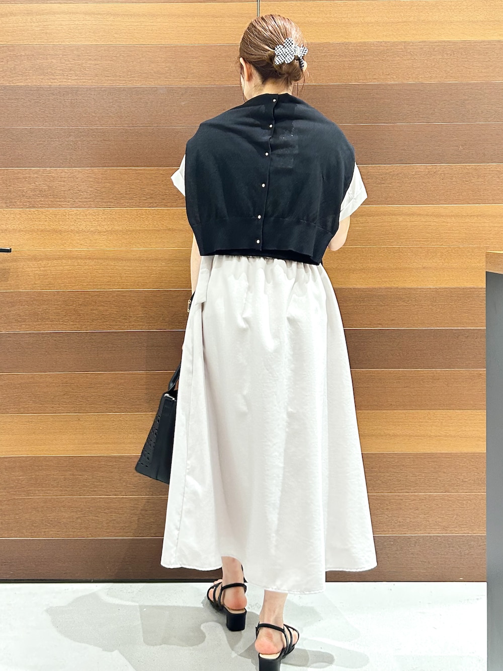 ブルー系のカーディガン/ボレロ、ベージュ系のワンピース、ブラック系のトートバッグを着用したレディースの夏コーディネートの4枚目の写真