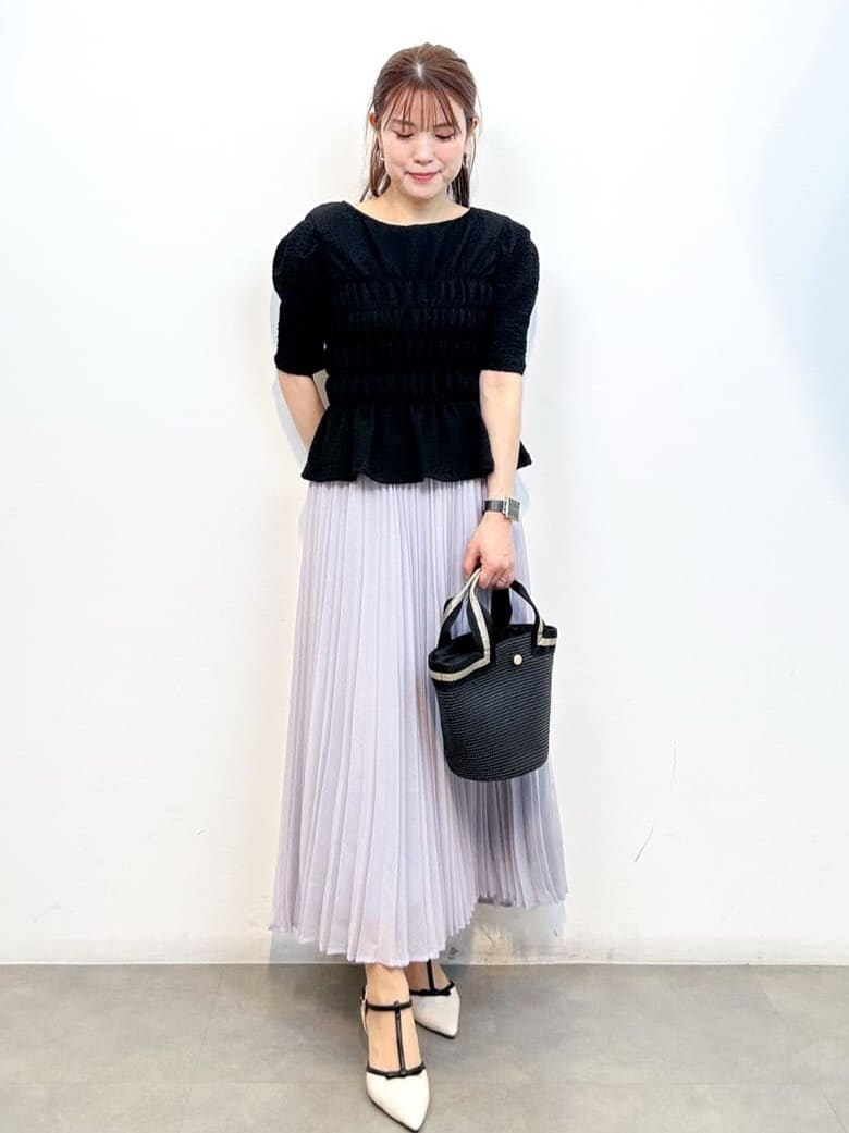 ブラック系のTシャツ/カットソー、ブラック系のトートバッグ、ホワイト系のパンプスを着用したレディースの春コーディネートの2枚目の写真