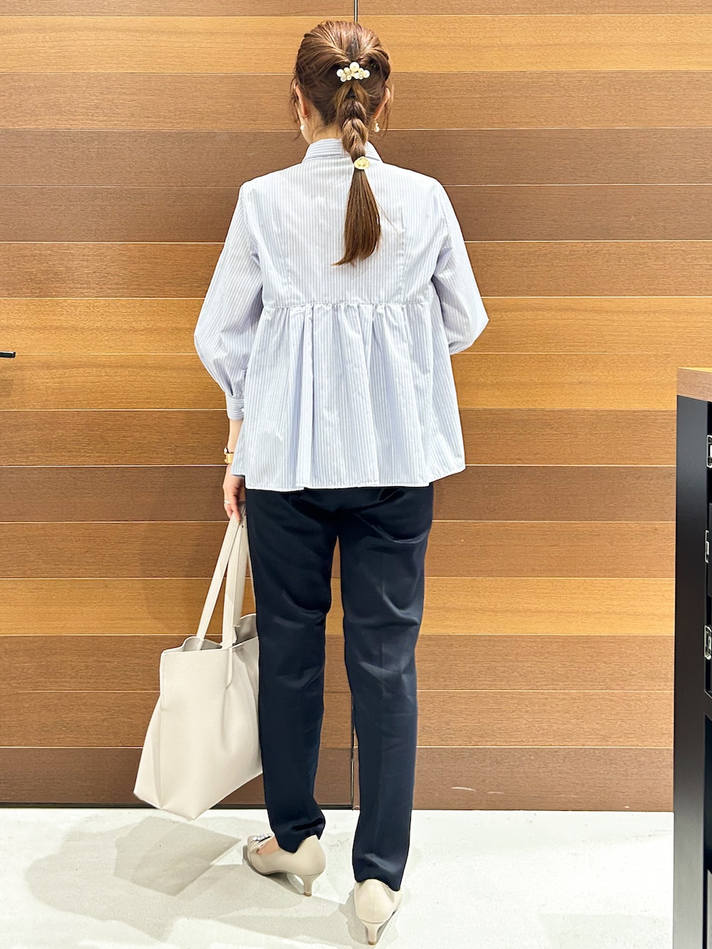 ベージュ系のパンプス、ブルー系のシャツ/ブラウス、グレー系のトートバッグを着用したレディースの春コーディネートの6枚目の写真