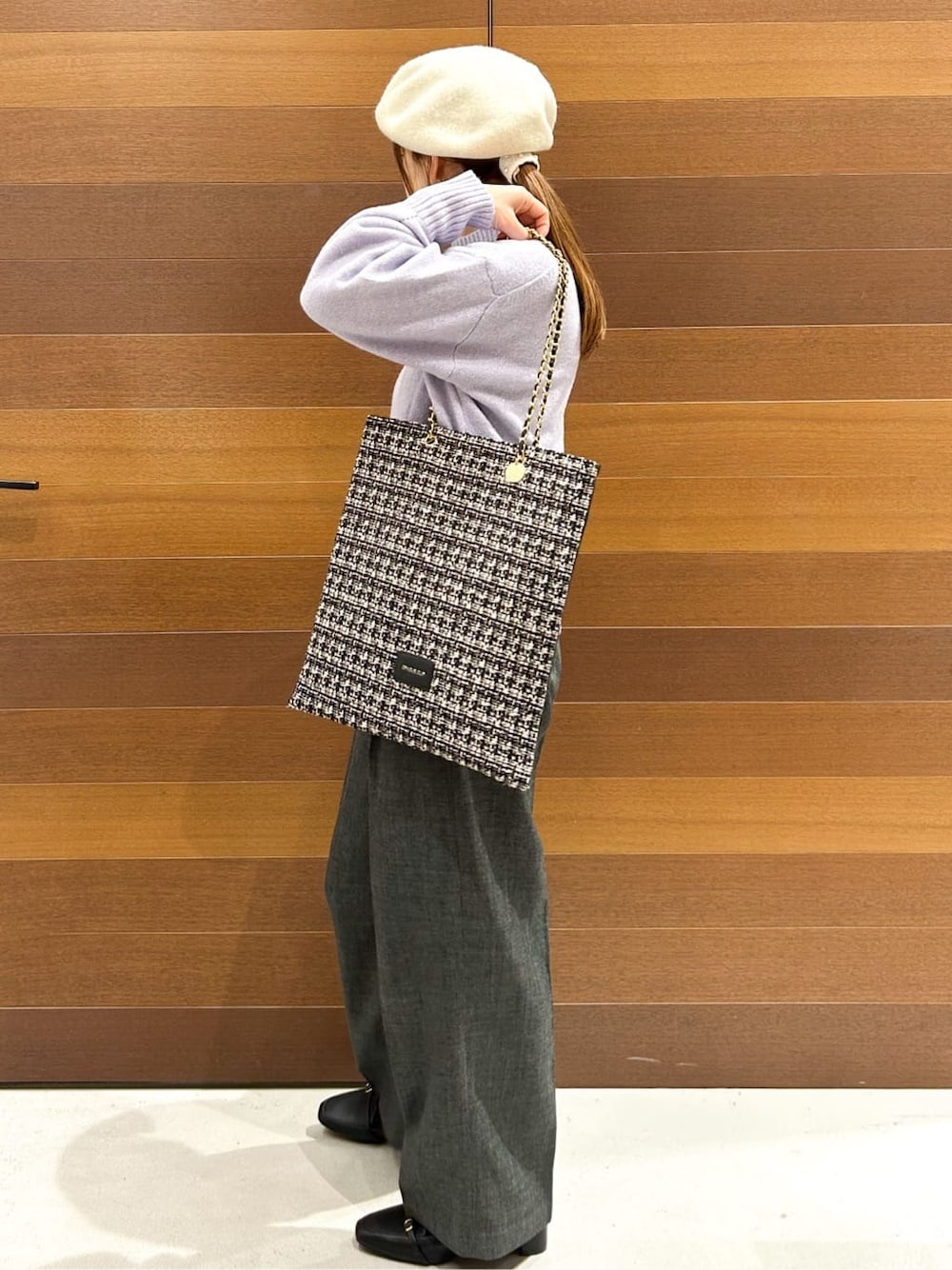 パープル系のニット/セーター、グレー系のその他パンツ、ブラック系のトートバッグを着用したレディースの冬コーディネートの5枚目の写真