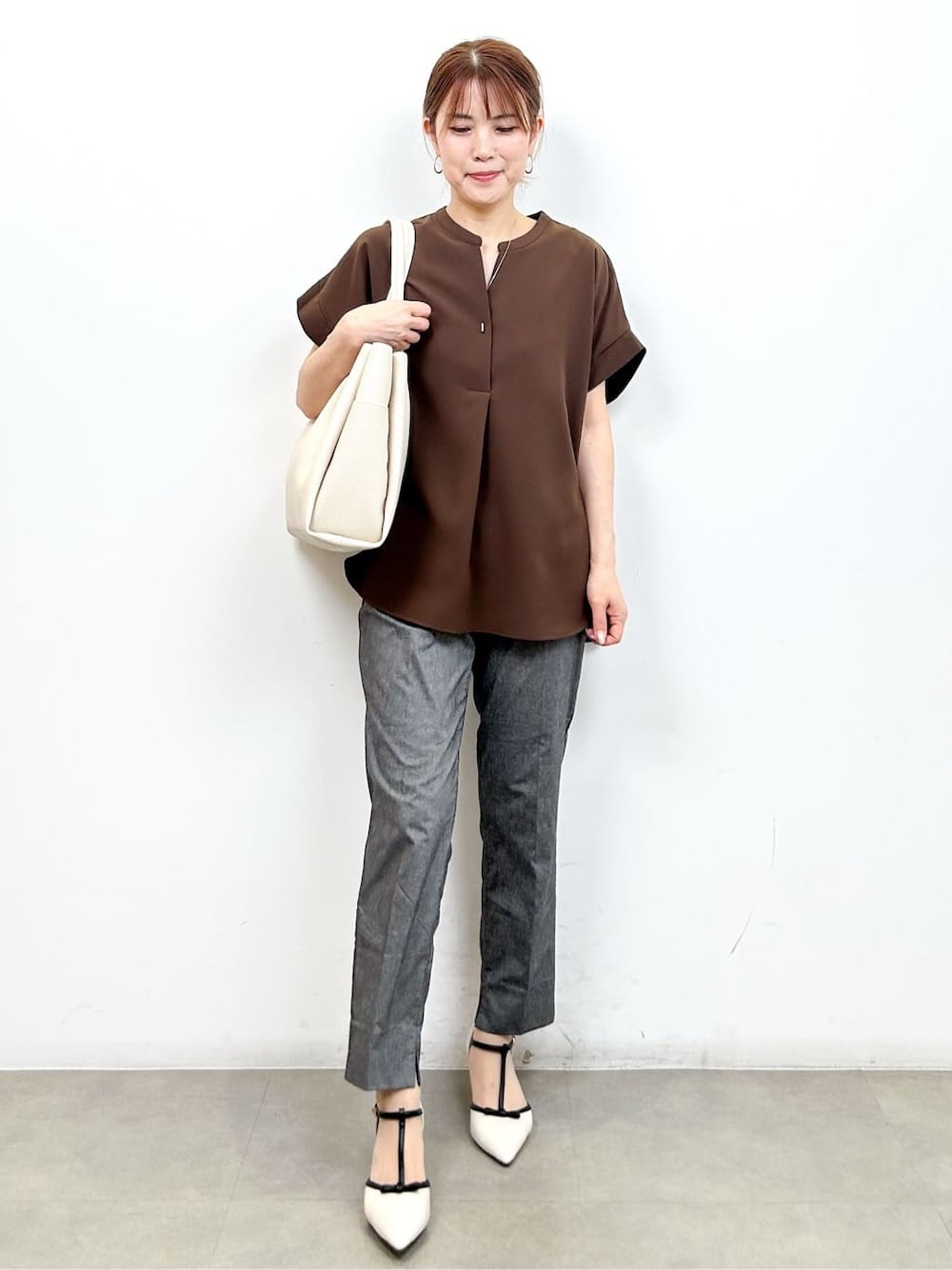 ブラウン系のシャツ/ブラウス、グレー系のその他パンツ、ホワイト系のトートバッグを着用したレディースの夏コーディネートの3枚目の写真
