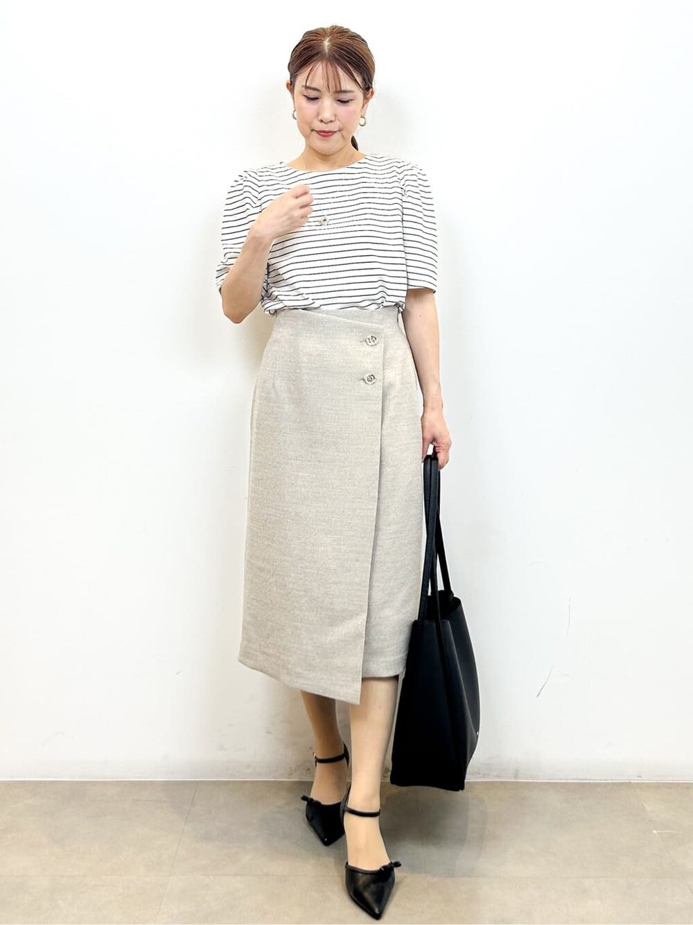 ホワイト系のTシャツ/カットソー、ベージュ系のスカート、ブラック系のトートバッグを着用したレディースの夏コーディネートの3枚目の写真