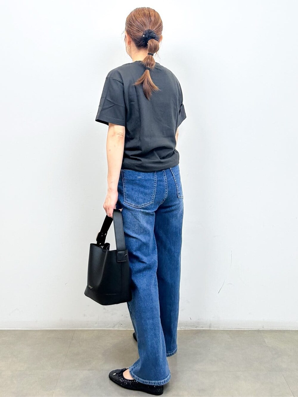 グレー系のTシャツ/カットソー、ブルー系のデニムパンツ、ブラック系のショルダーバッグを着用したレディースの秋コーディネートの7枚目の写真