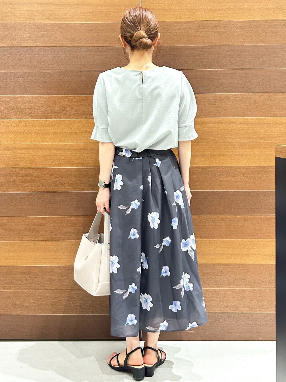 グリーン系のシャツ/ブラウス、グレー系のスカート、グレー系のトートバッグを着用したレディースの夏コーディネートの6枚目の写真