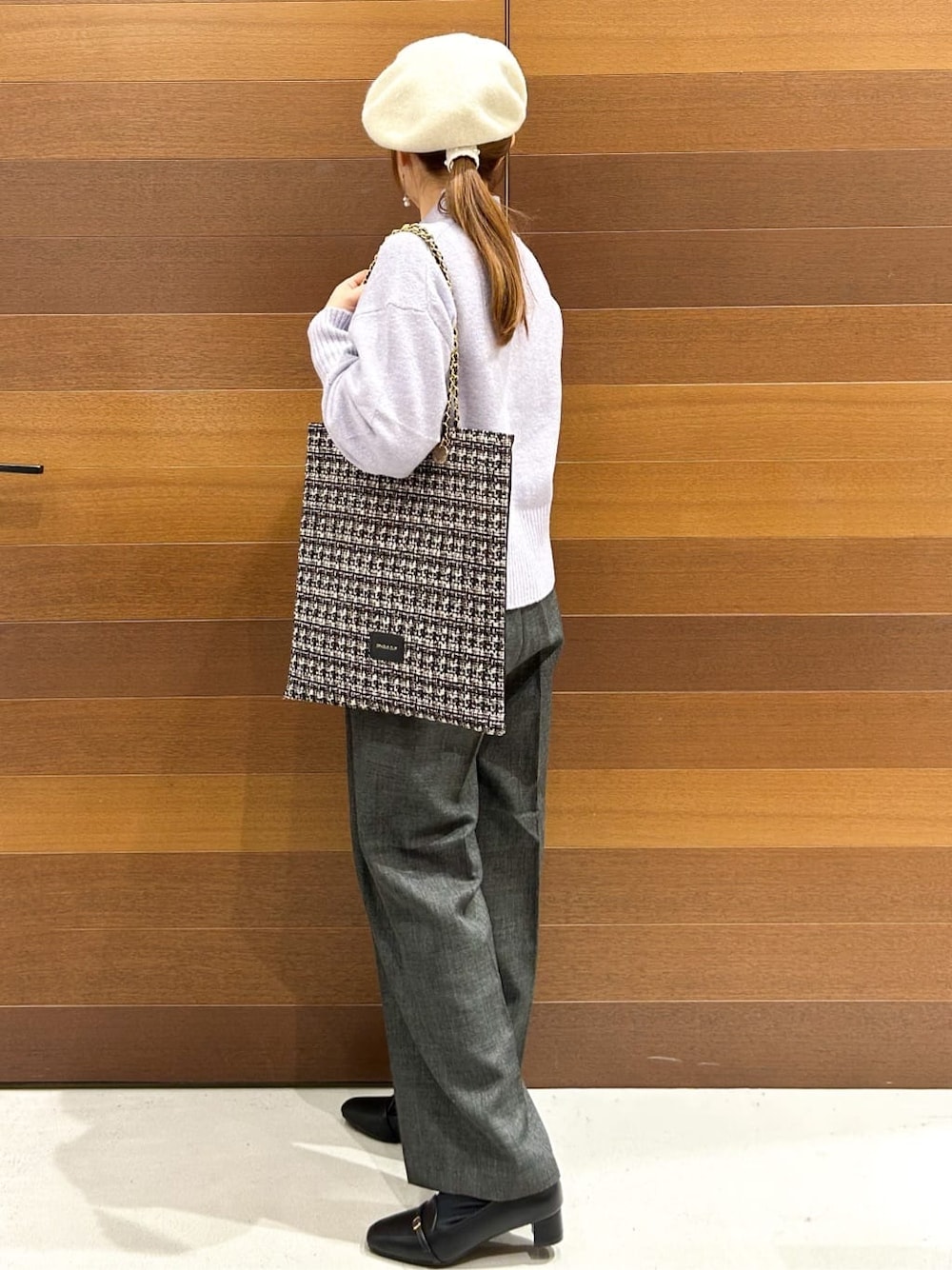 パープル系のニット/セーター、グレー系のその他パンツ、ブラック系のトートバッグを着用したレディースの冬コーディネートの6枚目の写真