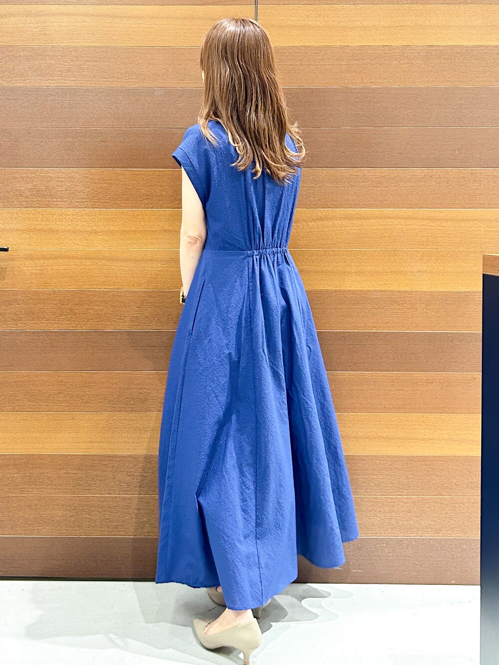 ブルー系のワンピース、グレー系のトートバッグ、ベージュ系のパンプスを着用したレディースの夏コーディネートの8枚目の写真