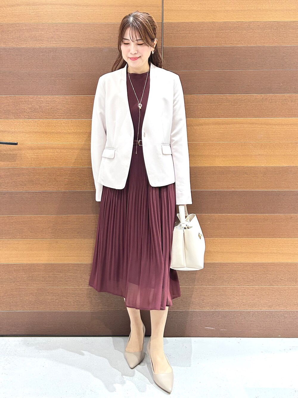 ベージュ系のノーカラージャケット、レッド系のワンピース、ホワイト系のハンドバッグを着用したレディースの秋コーディネートの8枚目の写真