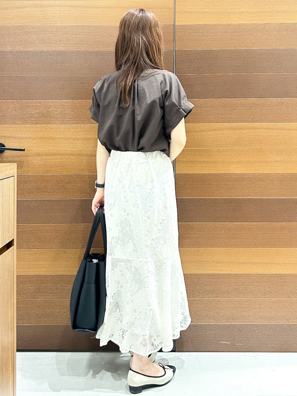 ブラウン系のシャツ/ブラウス、ホワイト系のスカート、ブラック系のトートバッグを着用したレディースの夏コーディネートの5枚目の写真