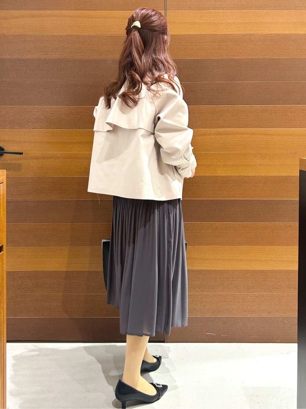ベージュ系のトレンチコート、グレー系のワンピース、ブラック系のトートバッグを着用したレディースの春コーディネートの6枚目の写真