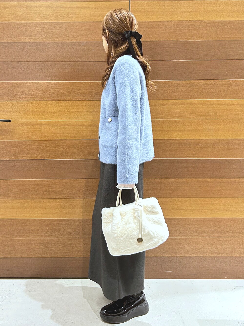 ブルー系のカーディガン/ボレロ、グレー系のTシャツ/カットソー、グレー系のスカートを着用したレディースの秋コーディネートの5枚目の写真
