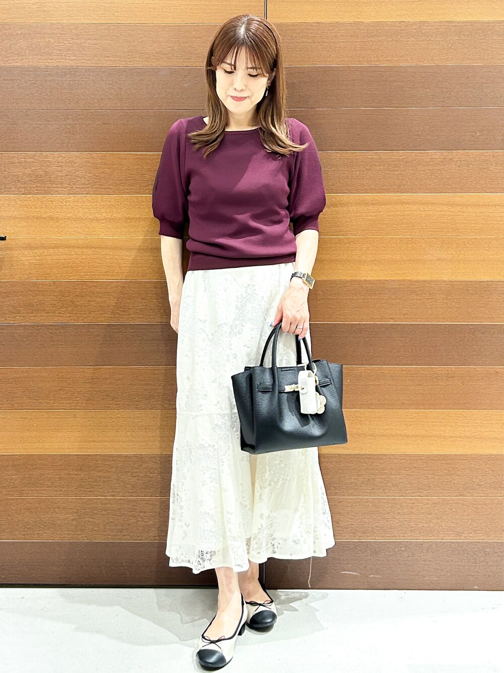 ホワイト系のスカート、ブラック系のトートバッグ、ベージュ系のパンプスを着用したレディースの夏コーディネートの3枚目の写真