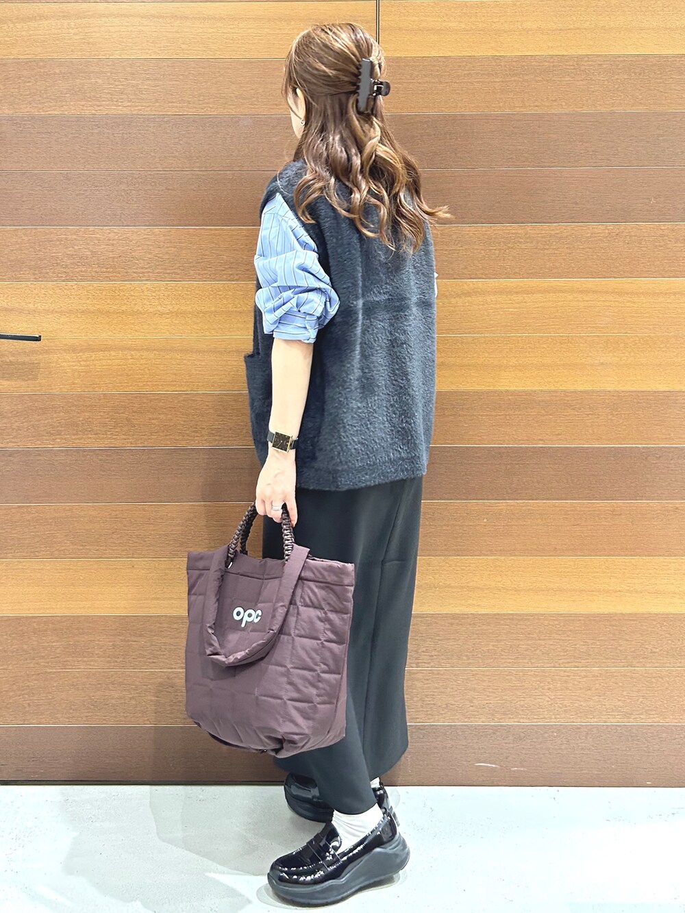 グレー系のニット/セーター、ブルー系のシャツ/ブラウス、ブラック系のスカートを着用したレディースの秋コーディネートの4枚目の写真