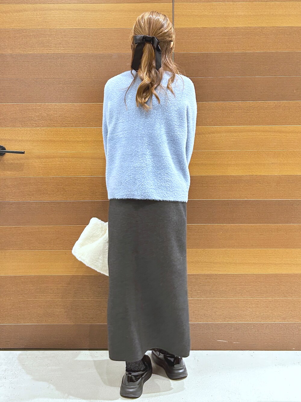 ブルー系のカーディガン/ボレロ、グレー系のTシャツ/カットソー、グレー系のスカートを着用したレディースの秋コーディネートの8枚目の写真