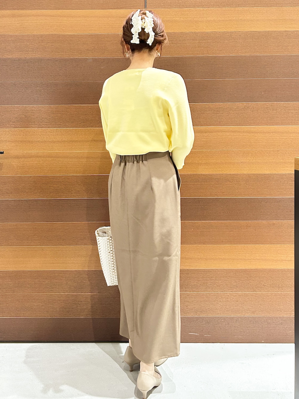 ベージュ系のパンプス、ベージュ系のショルダーバッグ、ブラウン系のスカートを着用したレディースの春コーディネートの6枚目の写真