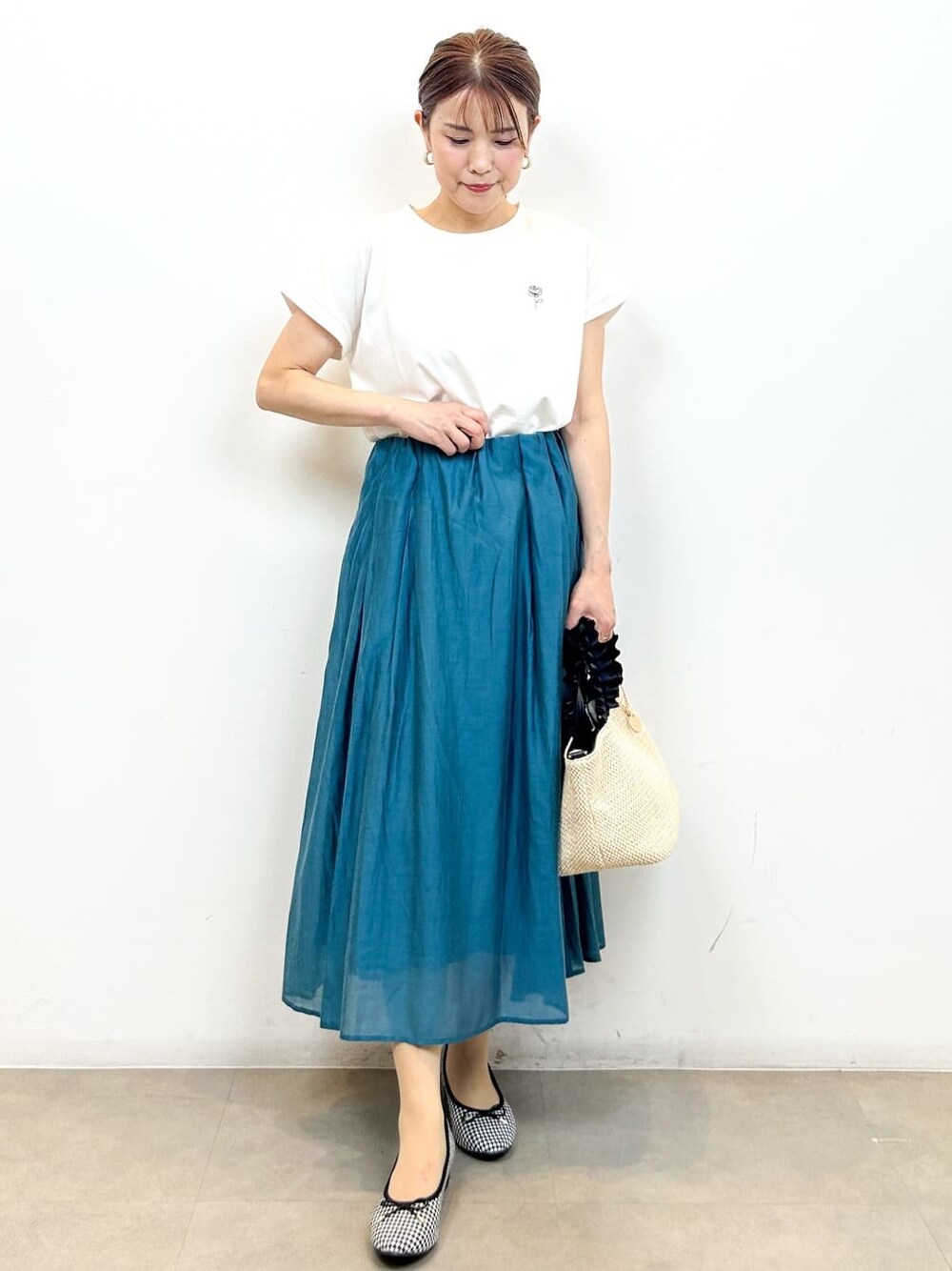 ホワイト系のTシャツ/カットソー、ブルー系のスカート、ブラック系のトートバッグを着用したレディースの夏コーディネートの4枚目の写真