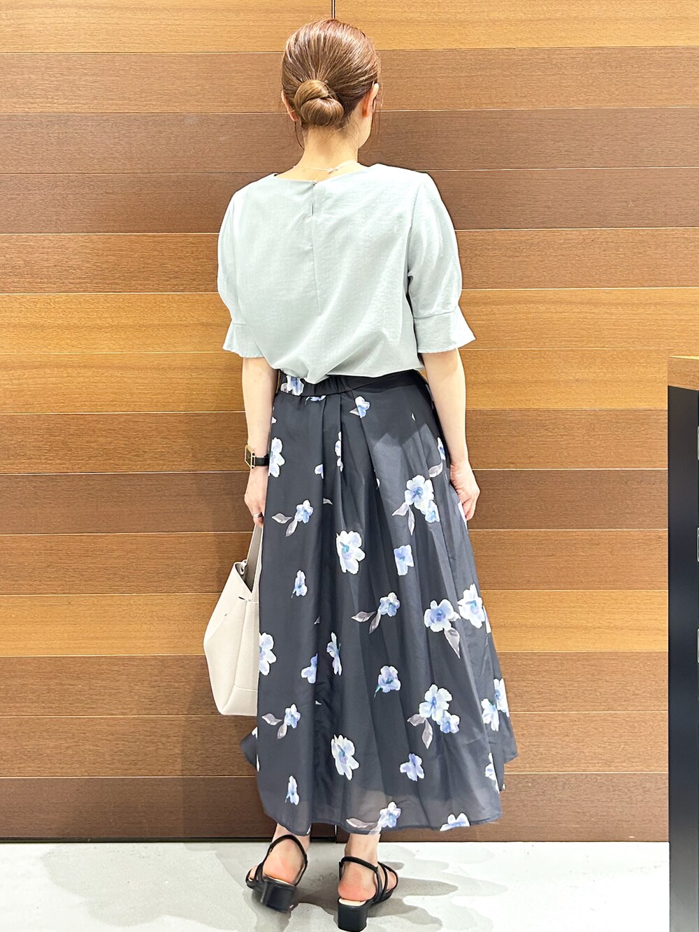 グリーン系のシャツ/ブラウス、グレー系のスカート、グレー系のトートバッグを着用したレディースの夏コーディネートの7枚目の写真
