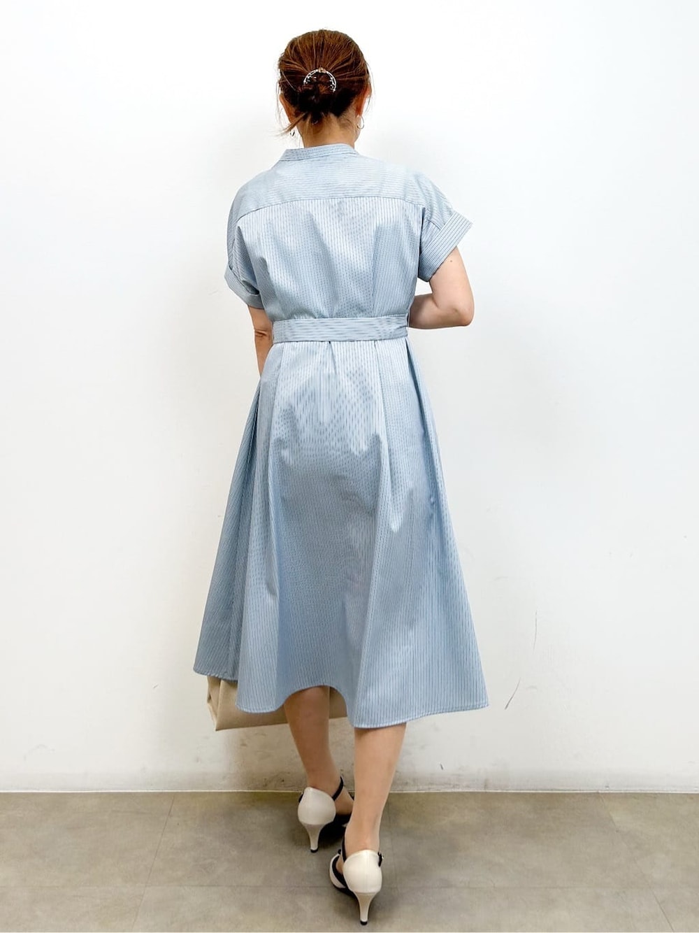 ブルー系のワンピース、ホワイト系のトートバッグ、ホワイト系のパンプスを着用したレディースの夏コーディネートの7枚目の写真