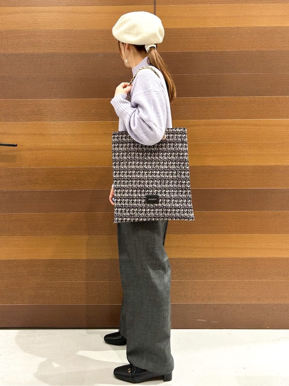 パープル系のニット/セーター、グレー系のその他パンツ、ブラック系のトートバッグを着用したレディースの冬コーディネートの7枚目の写真