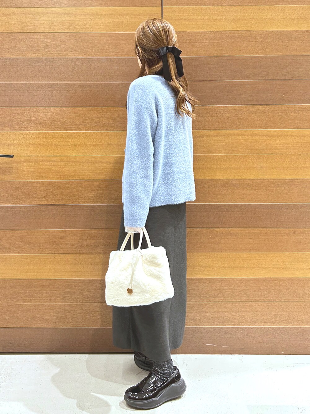 ブルー系のカーディガン/ボレロ、グレー系のTシャツ/カットソー、グレー系のスカートを着用したレディースの秋コーディネートの6枚目の写真