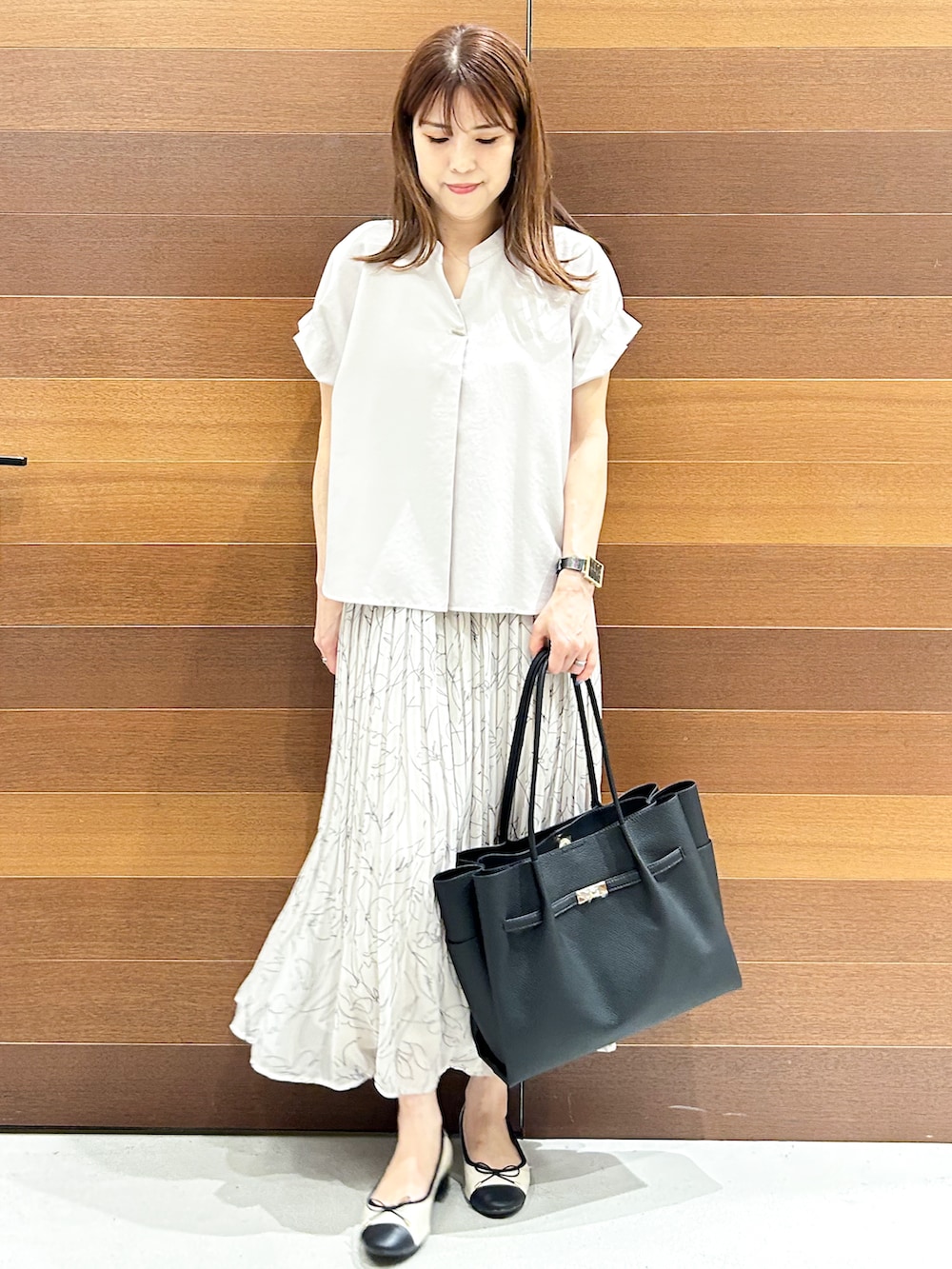 ベージュ系のシャツ/ブラウス、ブラック系のトートバッグ、ベージュ系のパンプスを着用したレディースの夏コーディネートの2枚目の写真
