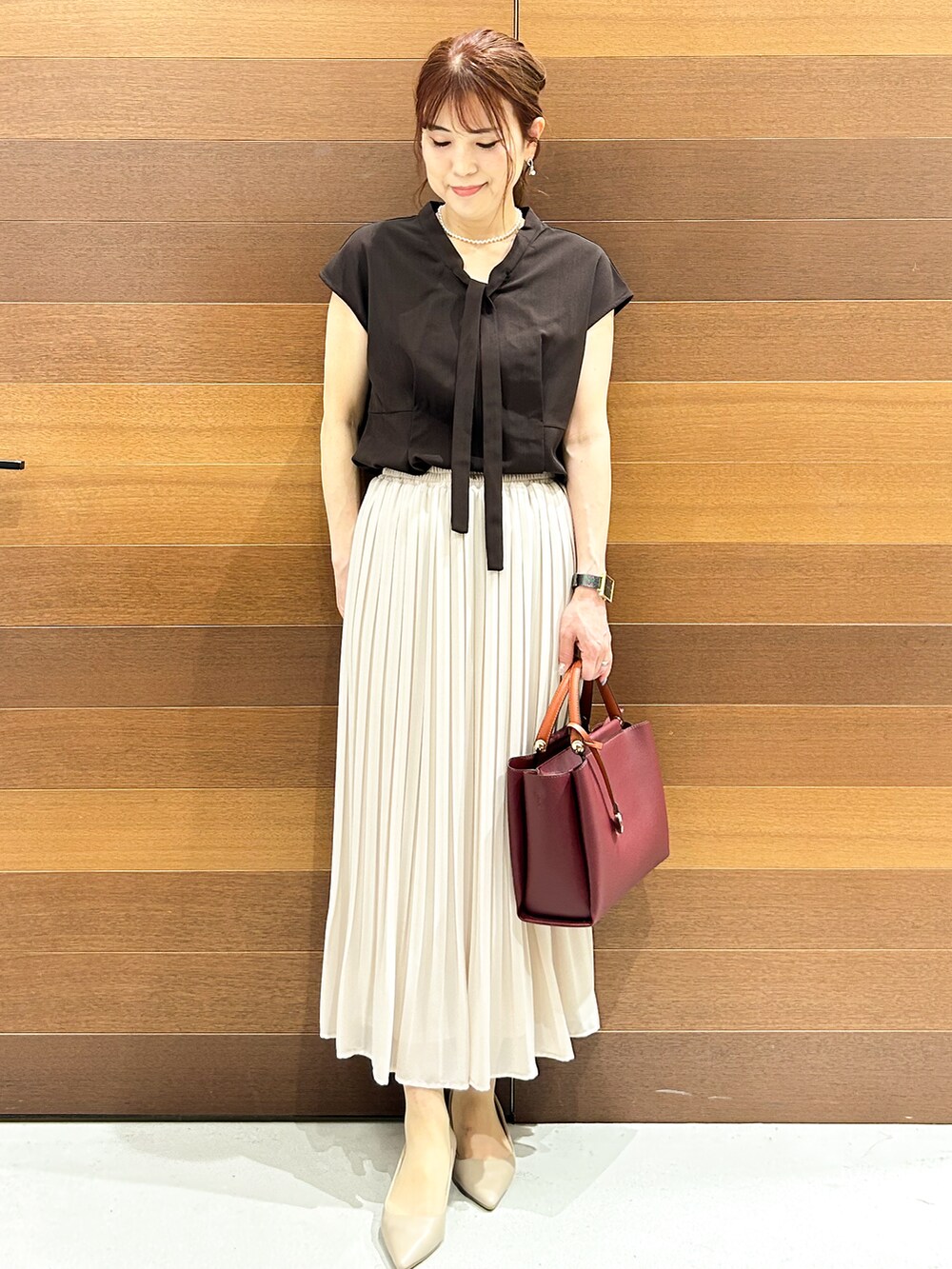 ブラウン系のシャツ/ブラウス、ベージュ系のスカート、レッド系のトートバッグを着用したレディースの夏コーディネートの3枚目の写真