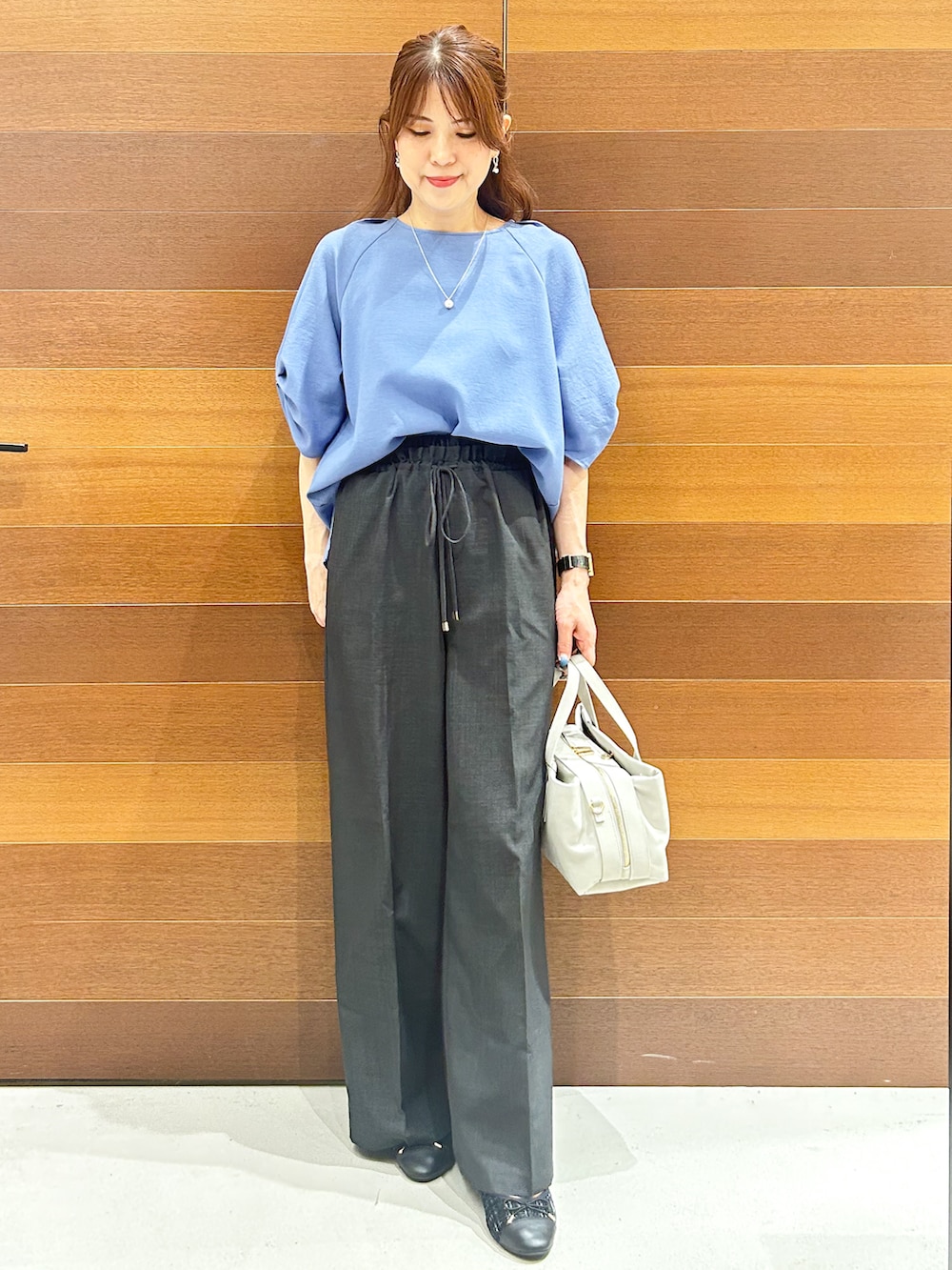 ブルー系のシャツ/ブラウス、グレー系のその他パンツ、グレー系のボストンバッグを着用したレディースの夏コーディネートの2枚目の写真