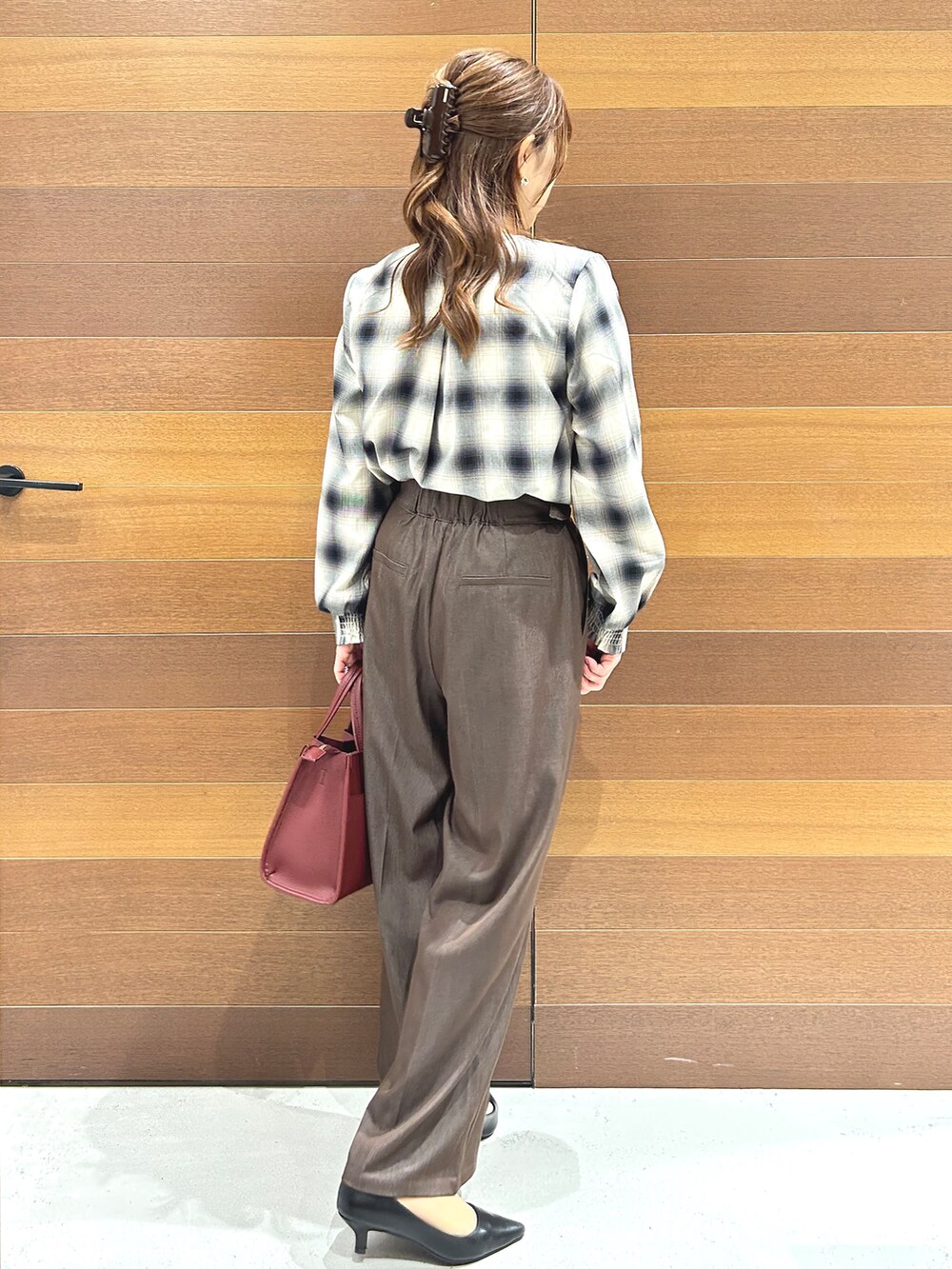 ブラウン系のシャツ/ブラウス、ブラウン系のその他パンツ、レッド系のトートバッグを着用したレディースの秋コーディネートの6枚目の写真