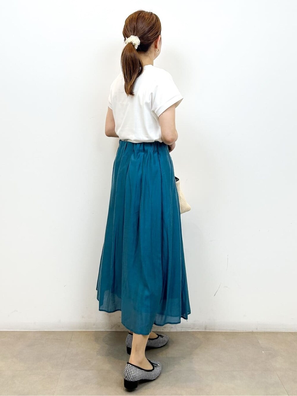 ホワイト系のTシャツ/カットソー、ブルー系のスカート、ブラック系のトートバッグを着用したレディースの夏コーディネートの7枚目の写真