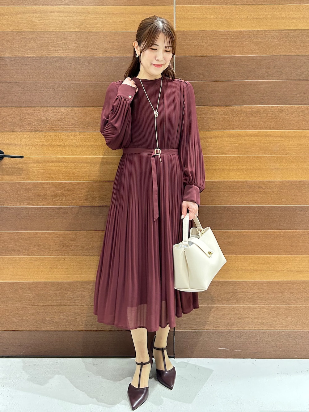 ベージュ系のノーカラージャケット、レッド系のワンピース、ホワイト系のハンドバッグを着用したレディースの秋コーディネートの8枚目の写真
