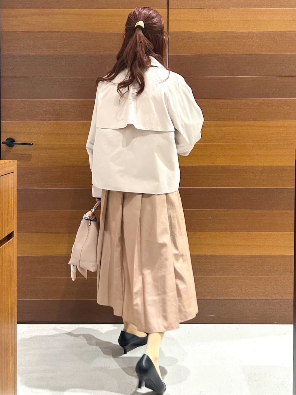 ベージュ系のトレンチコート、ブルー系のシャツ/ブラウス、ベージュ系のスカートを着用したレディースの春コーディネートの7枚目の写真