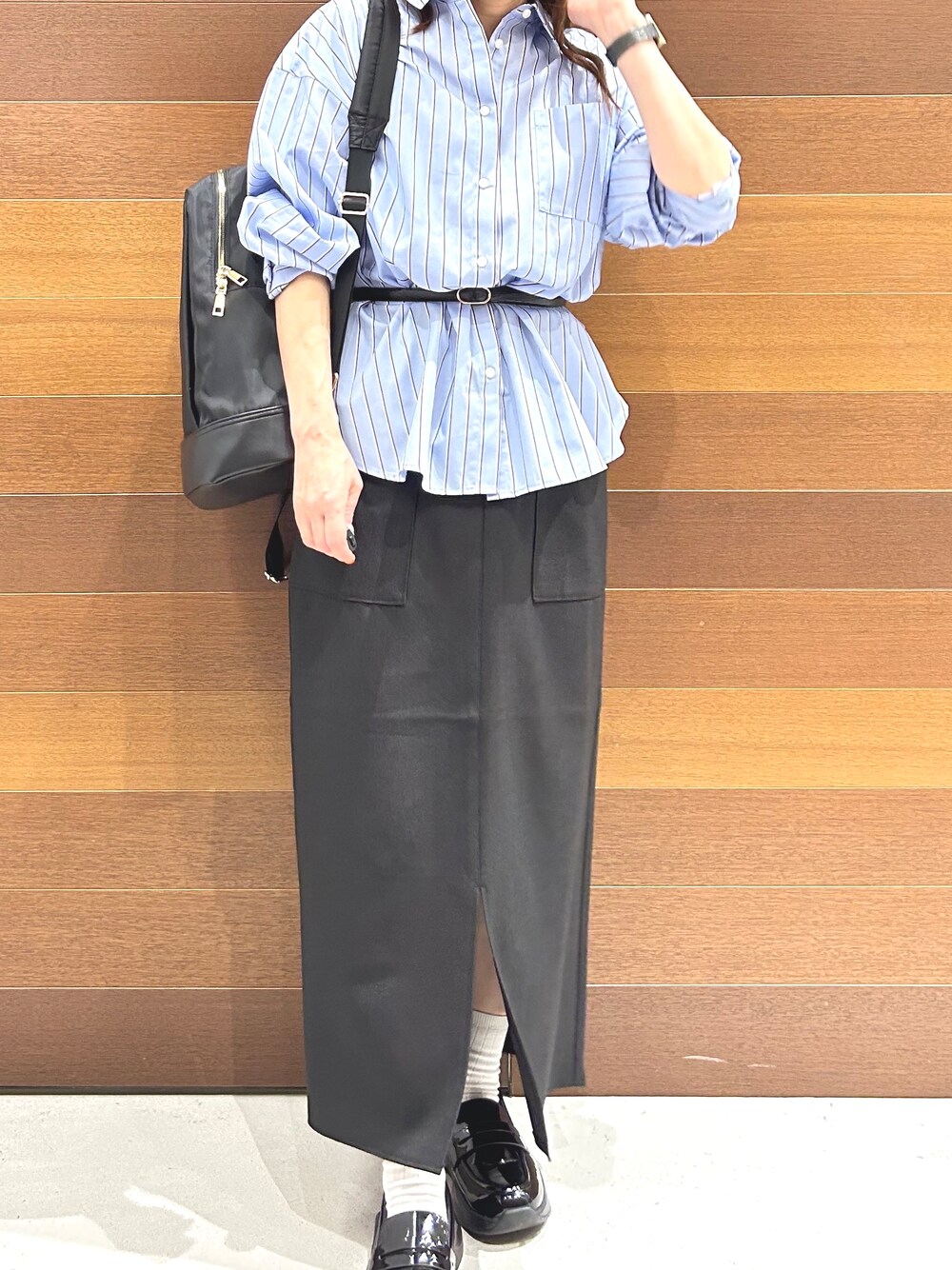 グレー系のニット/セーター、ブルー系のシャツ/ブラウス、ブラック系のスカートを着用したレディースの秋コーディネートの7枚目の写真
