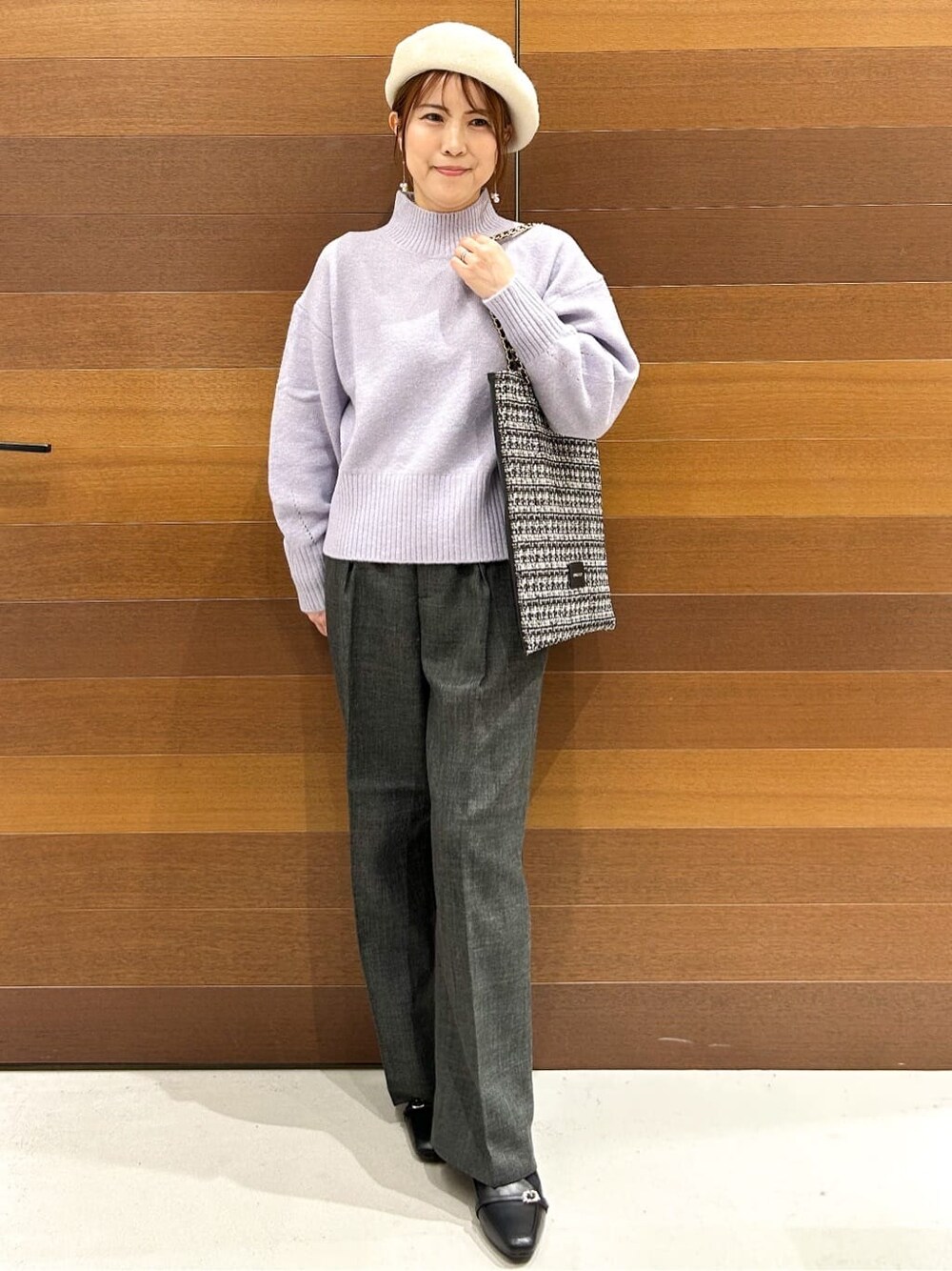 パープル系のニット/セーター、グレー系のその他パンツ、ブラック系のトートバッグを着用したレディースの冬コーディネートの4枚目の写真
