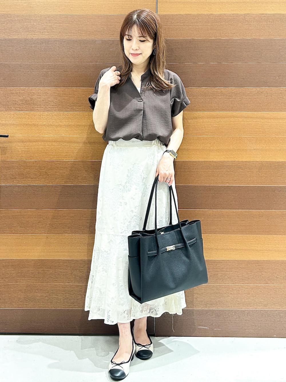 ブラウン系のシャツ/ブラウス、ホワイト系のスカート、ブラック系のトートバッグを着用したレディースの夏コーディネートの2枚目の写真